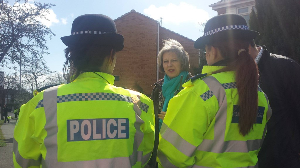 Theresa May talking with officers about the scheme 